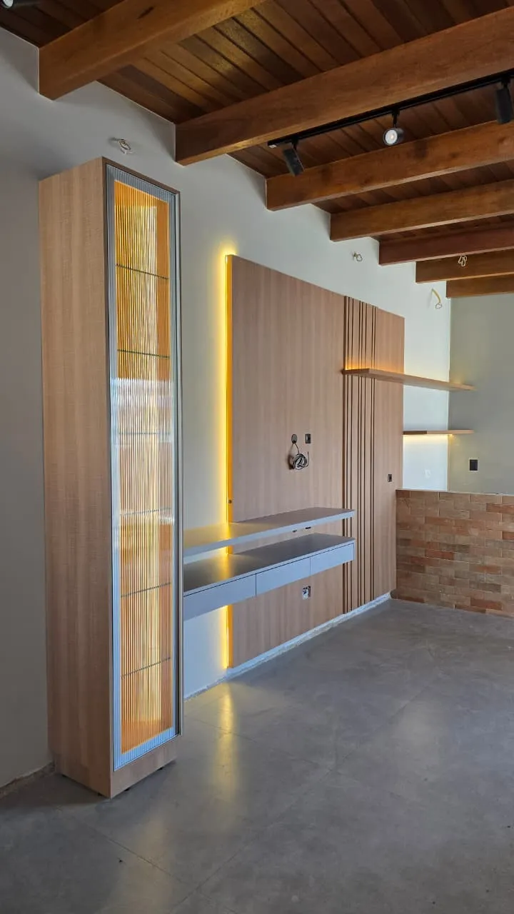 Torre com porta de vidro canelado iluminado em área gourmet